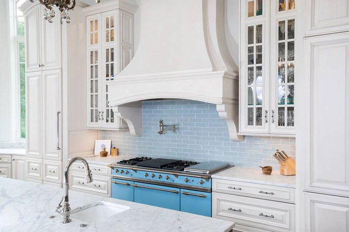 kitchen cabinet design studio in roanoke virginia features white cabinets with blue tile backsplash and white marble countertops and range hood