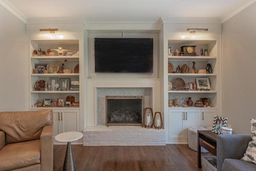 greg papenfus stewart living room design with side by side bookshelf cabinetry around fireplace
