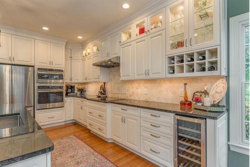 greg papenfus vaughan kitchen design white cabinetry and granite countertops with mini fridge