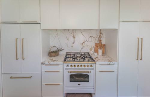 ideal cabinets adriana stevers design keeton kitchen range wall with white cabinets and gold handles